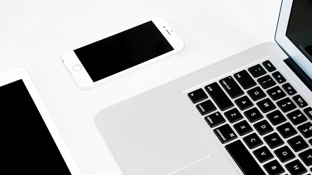 Vue plongeante d’un bureau de travail élégant avec deux écrans, un clavier, une souris et des accessoires contemporains.